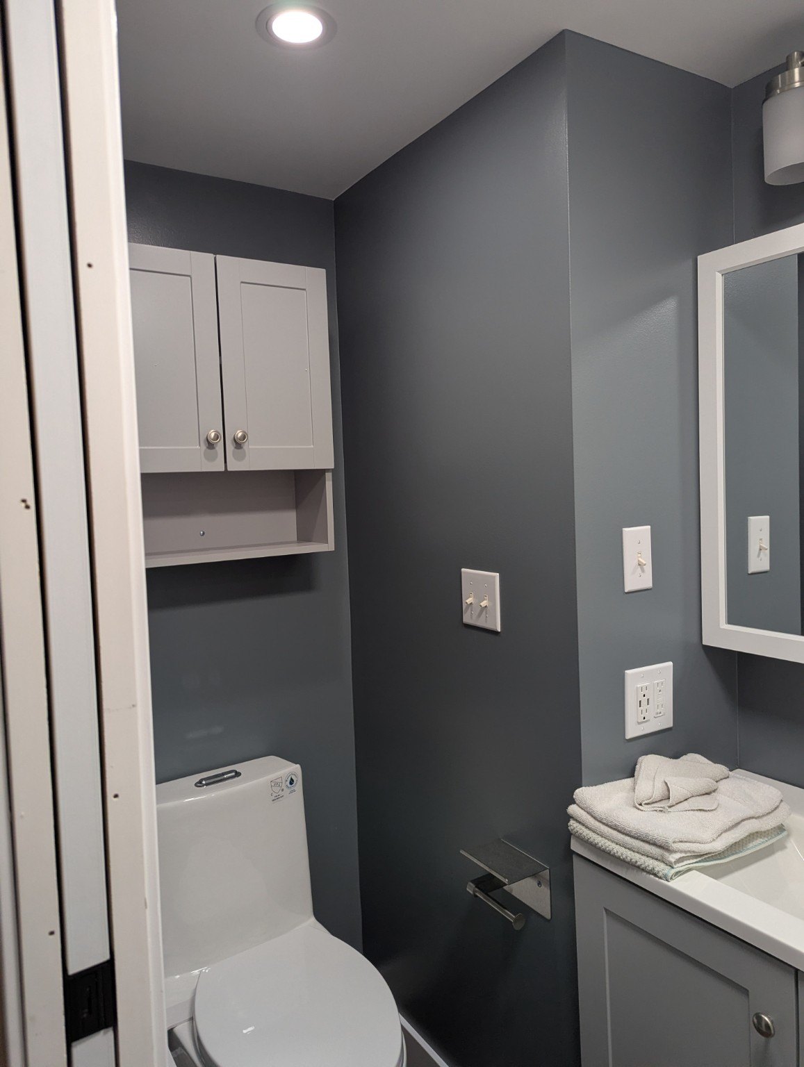 Finished bathroom vanity with painted walls and white trim.